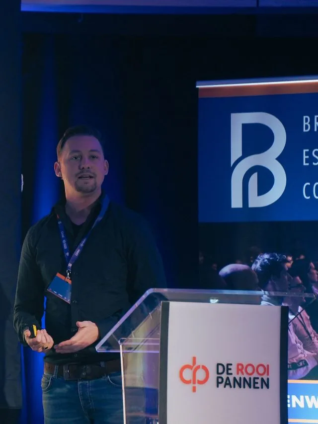 Max van Kuipers spreekt achter een katheder op een podium